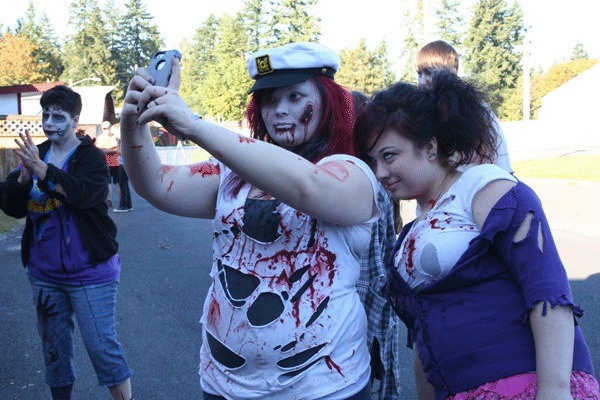 Kitsap Haunted Fairgrounds volunteers Kymber Thomas and  Christina Wright pose together for a photo after finishing their makeup in preparation for a night of scaring guests. Volunteers start their transformations at 3 p.m. on event nights.