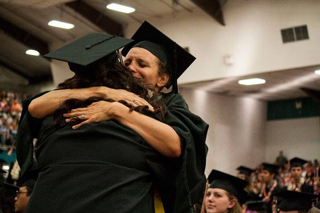 Central Kitsap High School vocal music teacher Alicia Lundberg hugs a graduating senior at the class of 2013’s commencement ceremony at the Kitsap County Fairgrounds Saturday