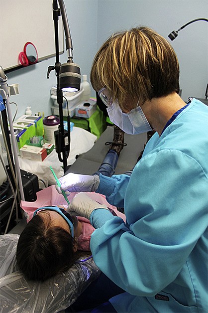 A student gets a dental check by Smile Partners staff.