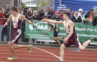 South Kitsap’s Zach Sleigh (left) takes the baton from Adam Gascoyne during the second leg of the Class 4A state track and field championship 4x400 meter relay race at Mount Tahoma High School.