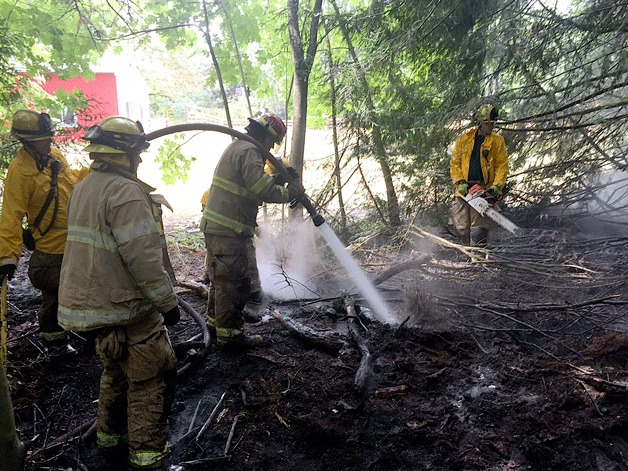 North Kitsap Fire & Rescue firefighters work to ensure a brush fire is completely extinguished.