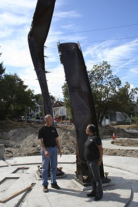 Dave Fergus (left) and Margie Torbron chat after the steel beams from the World Trade Center were placed in Evergreen Park last Saturday. A dedication is planned for Sept. 11.