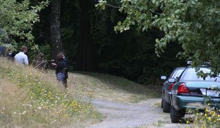 Kitsap County Sheriff's detectives stand outside of the home on Sunde Road in Silverdale where two men were detained after Department of Corrections staff smelled marijuana coming from the residence. A search warrant revealed a significant amount of marijuana and illegal explosives.