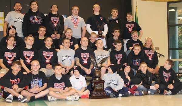 The Kingston Outlaws wrestlers that competed in Reno April 13-15 posed in front of their team trophy April 17 in the Kingston Middle School Commons. The team returned with a 15 and under trophy and three individual awards.