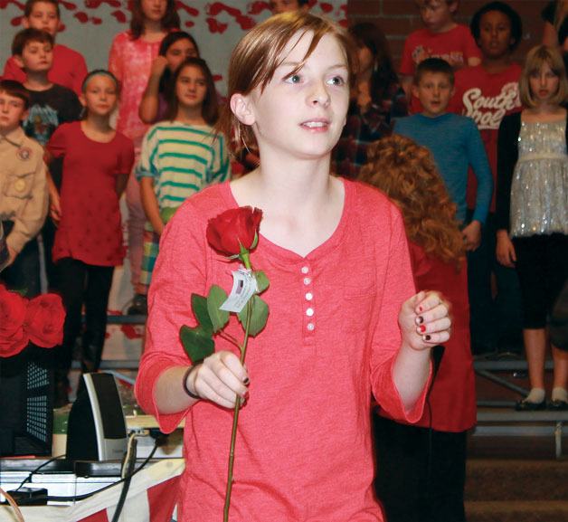Olalla Elementary School student Hailey Richardson waits to give a rose to a veteran during last week’s Veterans Day concert.