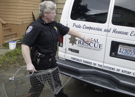 Animal control officer Jody Rosenblad removes a trap that was set in place to catch a stray cat in 2007.