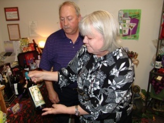Phil and Betty Harrison show off a bottle of their homemade wine with a custom label.
