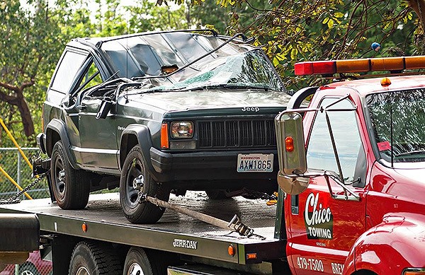 A crashed Jeep Cherokee sits atop a tow truck along Tibardis Road NW in Central Kitsap April 21.