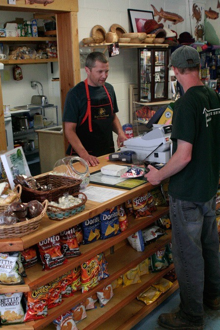 Lone Rock Grocery and Deli co-owner Bill Evalt serves a customer Wednesday at the store in Seabeck. Evalt and his wife
