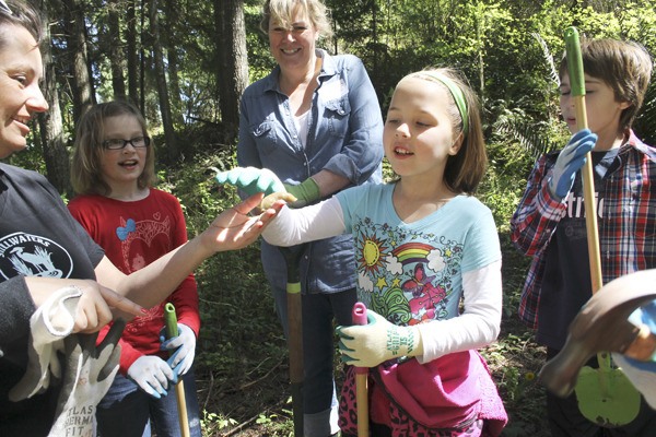 Kari Pelaez of Stillwaters Environmental Center shows off a banana slug to students Tess Eckert and Jessica Turner