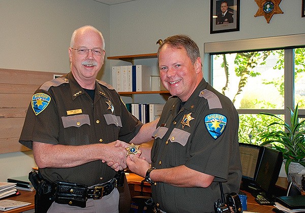 Kitsap County Sheriff Gary Simpson presents John Gese with a new sheriff’s star badge of office following the announcement of Gese’s appointment as undersheriff. A formal oath of office ceremony will be conducted at a future date.
