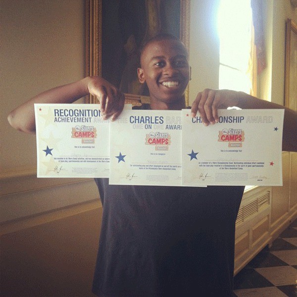 Wayne Ayers holds up certificates he won at NBA camps.
