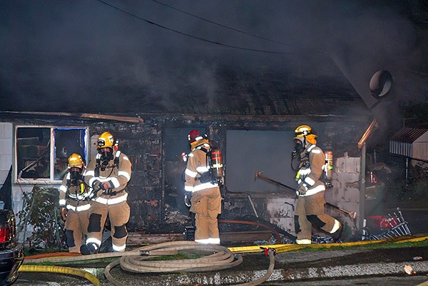 Firefighters work at the scene of a duplex fire on Stephenson Avenue in Bremerton around midnight Oct. 14.
