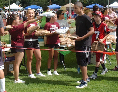 South Kitsap High School cheerleaders pass out bags of free school supplies during the annual SKSD Back-To-School Celebration on Saturday.