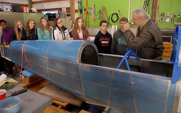CK Junior High students stand near a Van's Aircraft model RV-8 kit plane as pilot Scott Woodbury talks about aviation during a field trip to Apex Airpark on Nov. 12. From left is Madisyn Smith