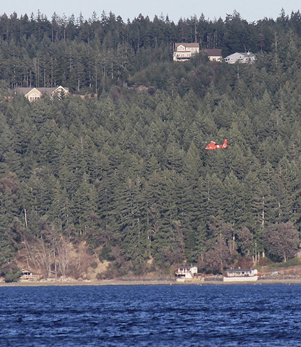 A Coast Guard helicopter searches Hood Canal