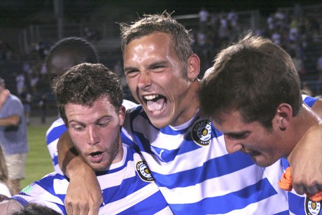 Kitsap Pumas midfielder Tony Kerr (middle) celebrates following the club’s 2-0 playoff victory July 25 over the Seattle Wolves at Bremerton Memorial Stadium.