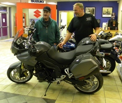 Salesman Daniel Durbin (right) points out the features of the  Triumph Tiger 1050 to a customer.