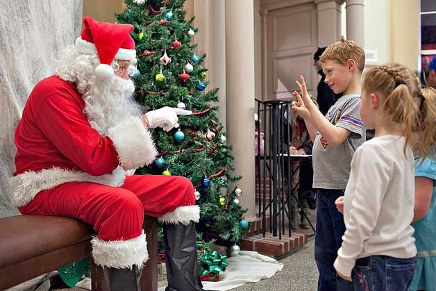 Santa discusses present wish lists with children at the 2014 Bremerton Winterfest.