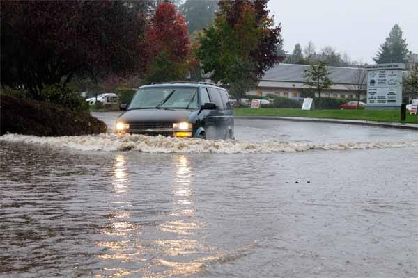 A minivan disperses water on 7th Avenue in Poulsbo Nov. 19 during heavy rainfall that caused flooding throughout Kitsap County. Shortly after the van passed through