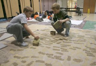 Sidney Glen fourth-graders Dylan Church and Ryan Green paint cobblestones on a set piece for the school's upcoming play ‘Frankenstein.’