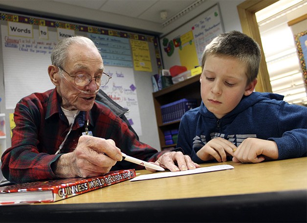 Grandpa Dan Schremser helps third grader Tyler Uffens.