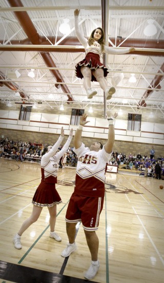 Kingston High School cheer captain Paul Thorpe works with his flyer