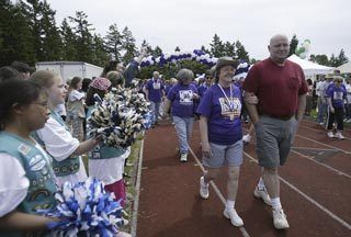 Girls Scouts from Troop 50599 of Bremerton wave pom-poms during the survivors lap at Relay for Life of Central Kitsap & Bremerton at the Central Kitsap High School track June 21.