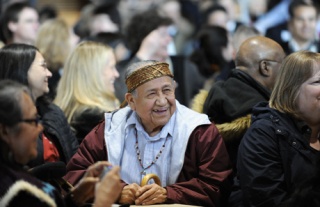 Suquamish Elder Oliver Jackson listens to students of the of the Marion Forsman-Boushie Early Learning Center perform a song during a ceremony honoring the Old Man House.