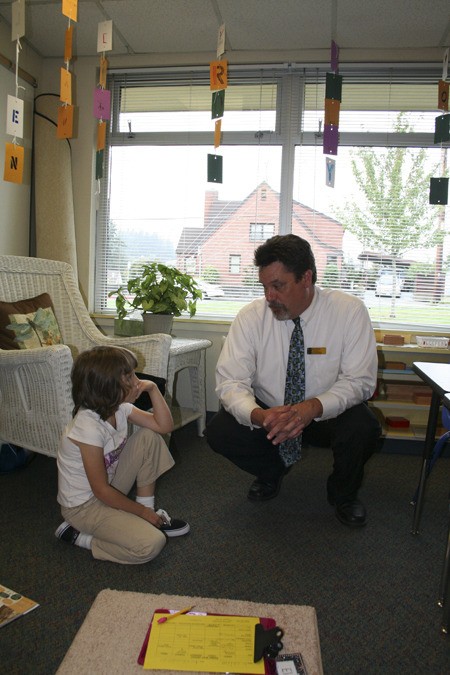 Naval Avenue Early Learning Center Principal John Welsh chats with second-grader Elaina Tacey in Liza Piper's Montessori class. The first through third grade Montessori at Naval Avenue