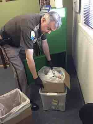 Sheriff Lt. John Sprague empties a 'take-back' bin at the sheriff's office. Residents are invited to bring back expired and unused medications instead of flushing the medication.