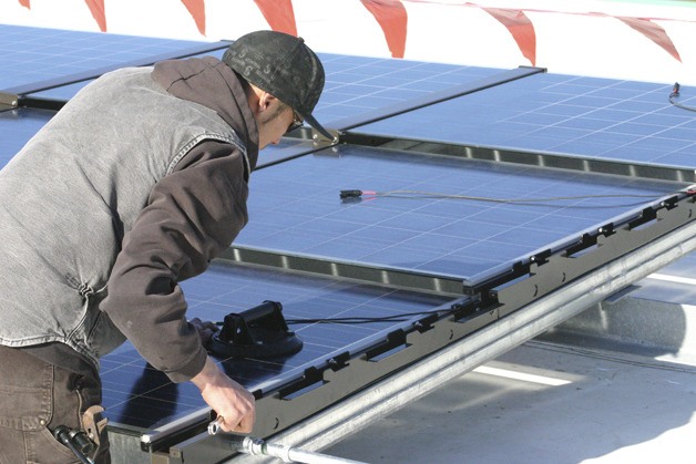 Bret Ortlieb of Fredrickson Electric adjusts a solar module on the roof of the Poulsbo Middle School gymnasium Feb. 4.