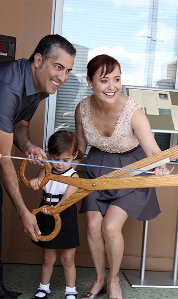 Carlos and Christina Jara cut the ribbon with the help of their daughter