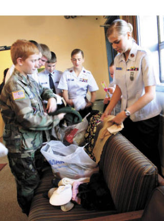 Civil Air Patrol Peninsula Composite Squadron 051 cadets sort through donations for their care package program Monday at Bremerton Airport. CAP is collecting winter clothing and food items for troops and contractors in Afghanistan and the Afghan people.