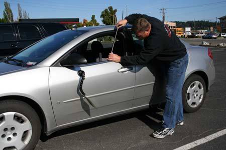 Flex-A-Dent owner Ron Pease fixes a dent on a car at the new Silverdale shop. Flex-A-Dent moved from Gorst to Silverdale in June.