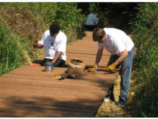 Teens from the YMCA summer youth employment program work on the boardwalk near All Star Lanes on the Clear Creek Trail July 27.