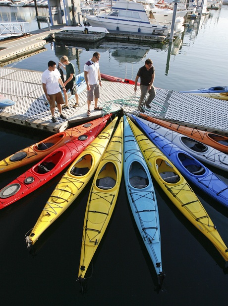 Olympic Outdoor Center owner John Kuntz maneuvers kayaks before the 2008 Dock Boys Olympics at the Poulsbo waterfront. After more than two decades in Poulsbo