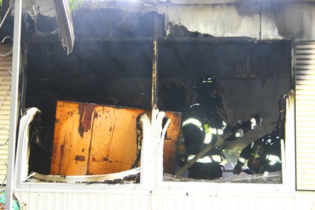 A firefighter checks for hotspots in a Poulsbo home that was destroyed in a Tuesday morning blaze.