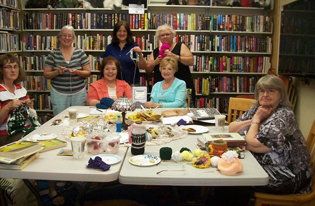 Members of Stitch a Cozy pose for a group photo. Silverdale Branch Library volunteer Jan Miller (standing