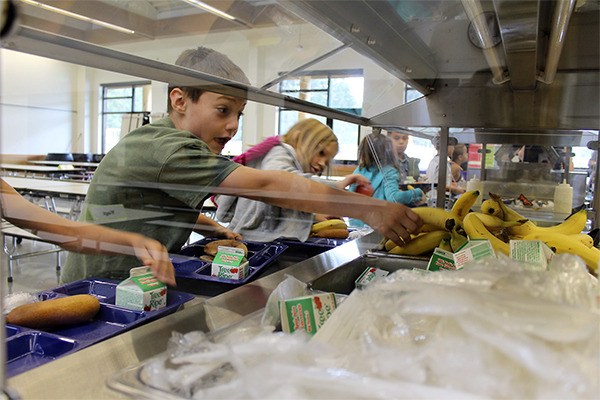 Students at John D. “Bud” Hawk Elementary at Jackson Park reach for fruits