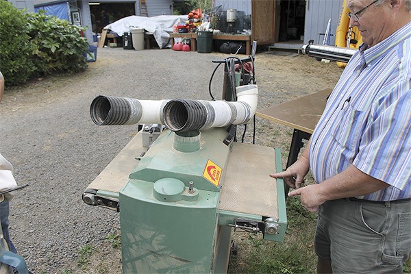 Greater Hansville Community Center board president Chuck Strahm shows a working table sander that will be for sale at the Hansville Rummage Sale Aug. 9-10 at Buck Lake County Park.