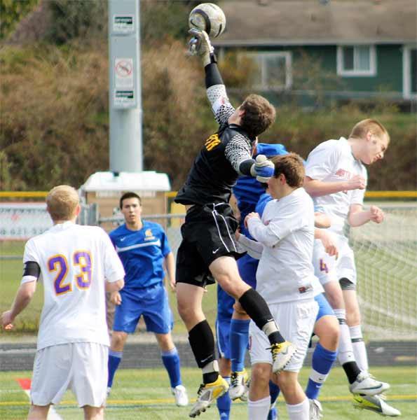 North Kitsap goalkeeper Jordan Hadden leaps for the soccer ball following a penalty kick from the Bainbridge Island Spartans. Hadden made at least five 'world-class' saves during the March 24 non-league game. North Kitsap won 1-0.