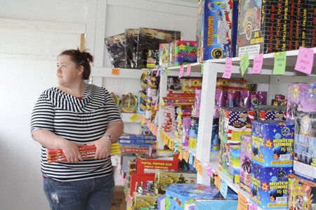 Barbara Douglas at Kitsap Fireworks in Silverdale helps customers select fireworks Tuesday.