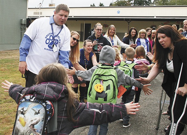 South Colby Elementary principal Joe Riley (left) and State Rep. Michelle Caldier welcome students to their first day of school Sept. 7. Below: Parents and school supporters were part of the celebration.