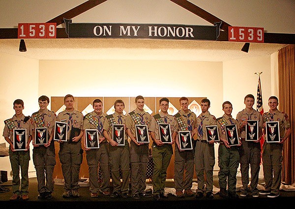Eagle Scouts stand with their peers for a photograph after the ceremony. Each Scout was given a framed award that included a hand carved eagle.