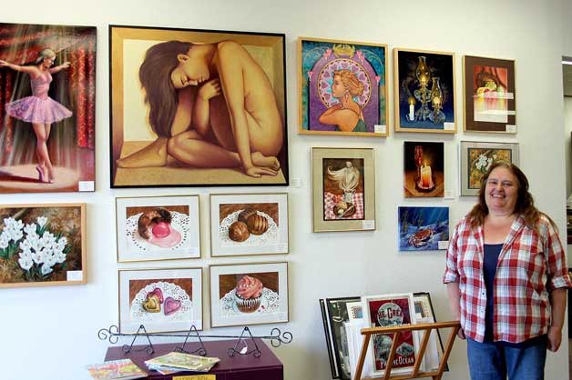 Sheila Peterson in front of a wall in her art gallery