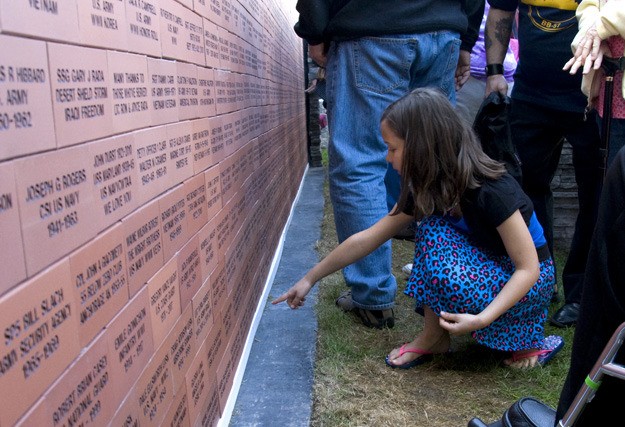 Silvia Smitha points to her grandfather's name on the Veteran's Wall of Honor.