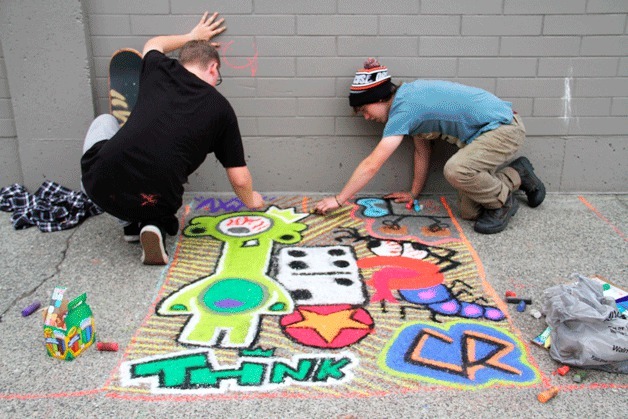 Cameron Wood and Colin Rose work on their chalk art creation at Bremerton's Blackberry Festival.