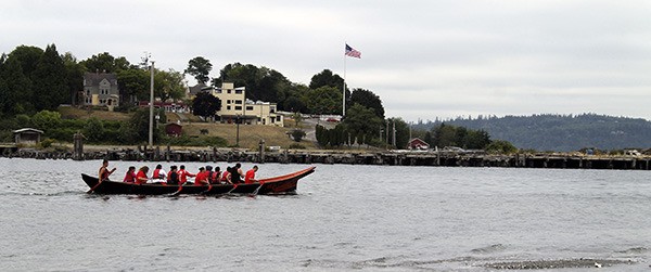 A Port Gamble S'Klallam canoe passes the former mill town of Port Gamble