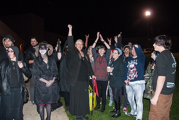 Members of The Satanic Temple of Seattle and Bremerton student supporters raise their hands in the air during the Bremerton football game Oct. 29.